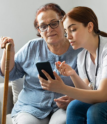 Nurse helping patient use SimpliHere app to communicate